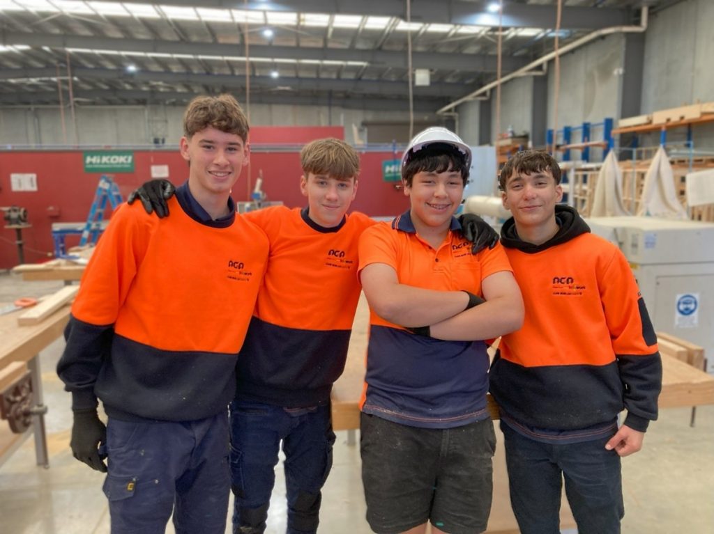 VDSS Students smiling to camera in workshop